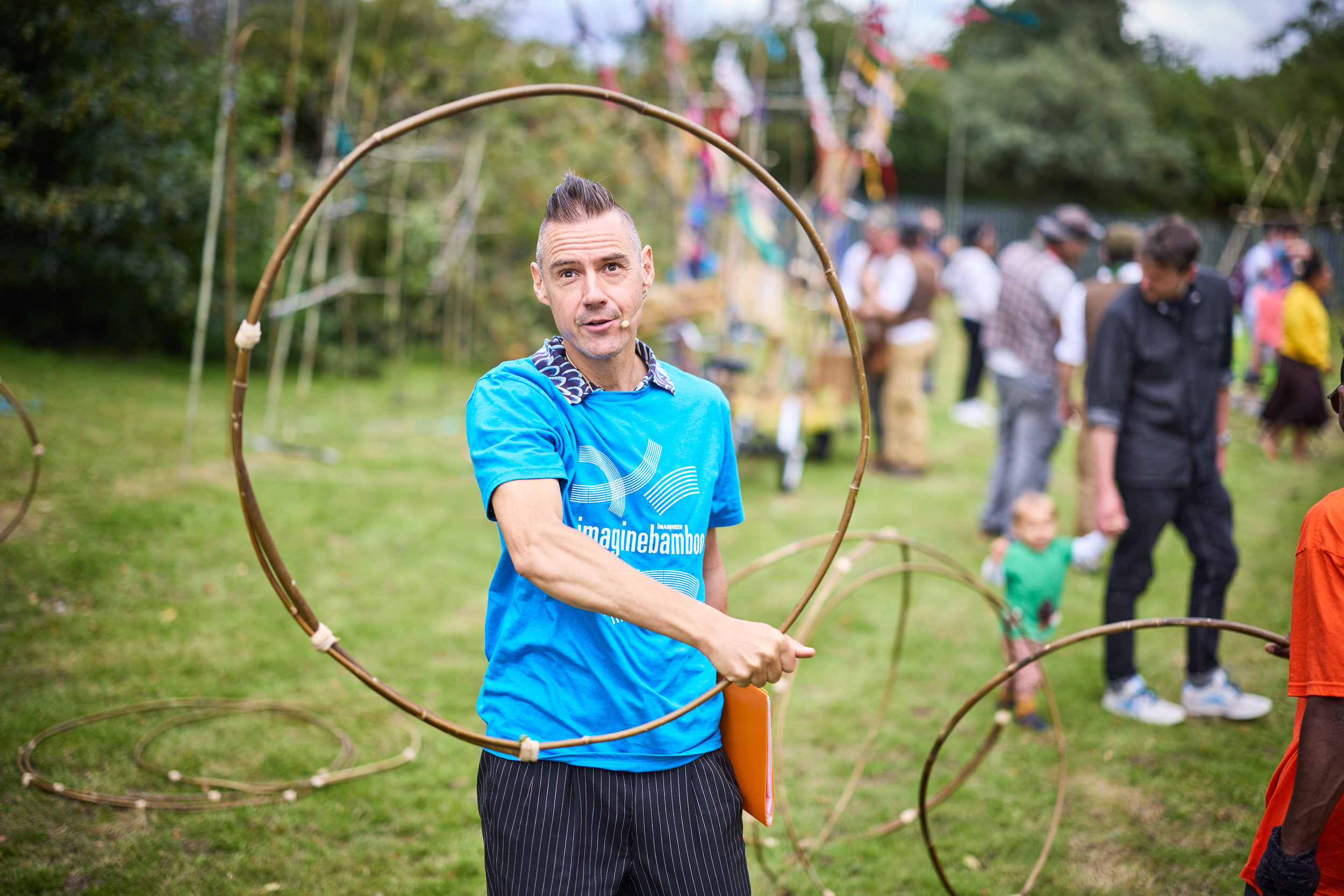 A man holds a hula hoop made of bamboo