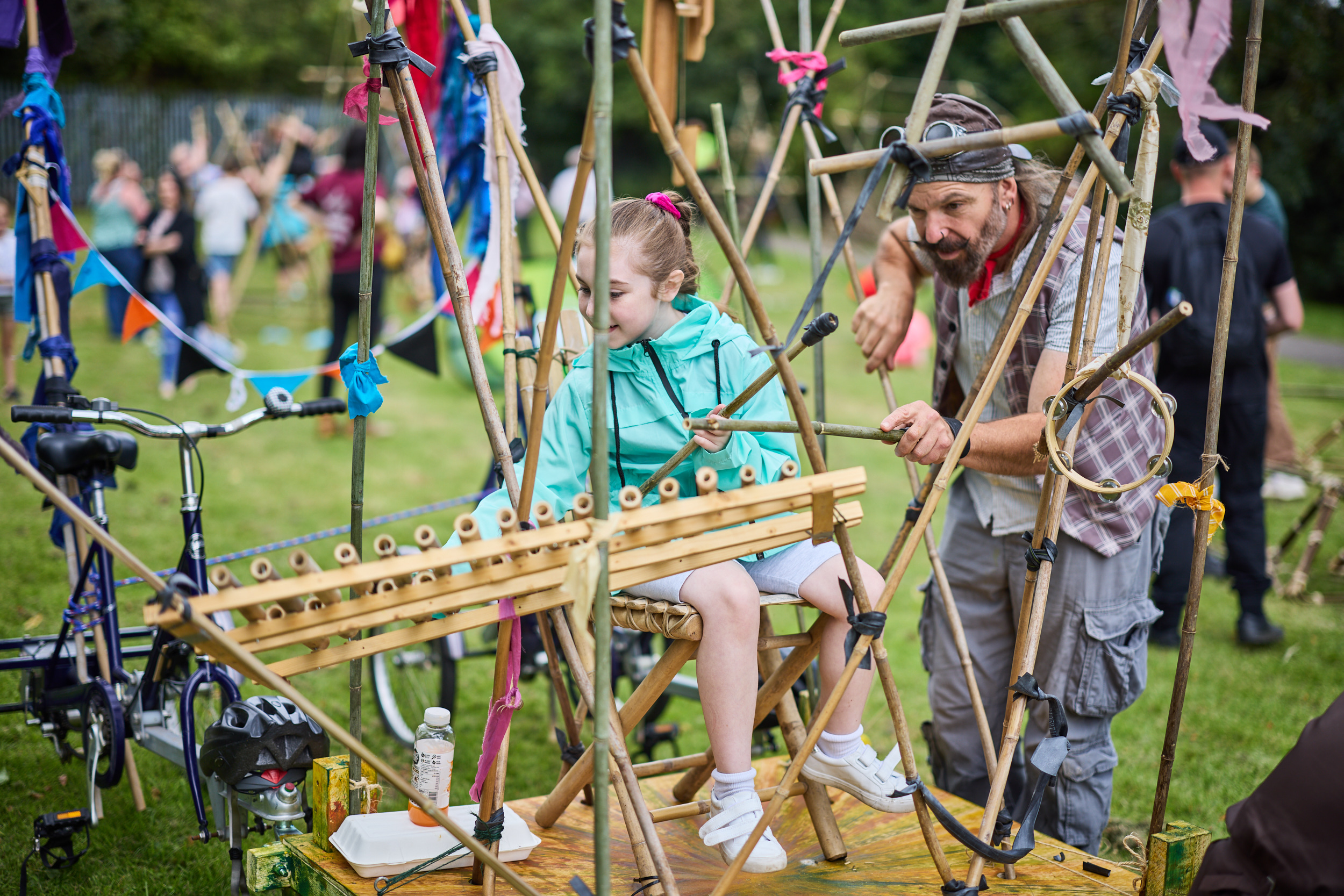 Children play musical instruments made of bamboo