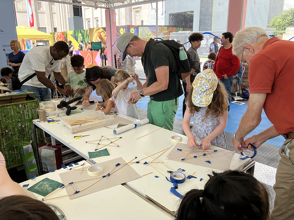 Parents and children crafting with bamboo sticks